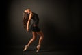 Young elegant ballet dancer, dressed in black jersey, shoes and weightless black skirt is demonstrating ability to dance.