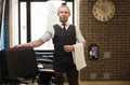 Barber invites to have seat on chair at barbershop