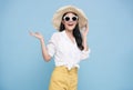 Young elegant beautiful Asian woman dressed in summer clothes smiling and pointing to empty copy space isolated on blue background Royalty Free Stock Photo