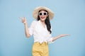 Young elegant beautiful Asian woman dressed in summer clothes smiling and pointing to empty copy space isolated on blue background Royalty Free Stock Photo