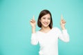Young elegant beautiful Asian woman smiling and pointing to empty copy space on green background Royalty Free Stock Photo