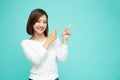 Young elegant beautiful Asian woman smiling and pointing to empty copy space on green background Royalty Free Stock Photo