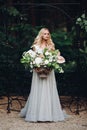 Young elegant beutiful blondy bride holding in hand wedding boquet. Royalty Free Stock Photo