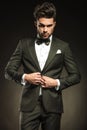 Young elegant business man arranging his tuxedo. Royalty Free Stock Photo