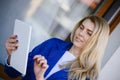 Young elegant business woman in blue jacket holding tablet. Royalty Free Stock Photo