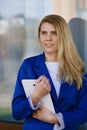 Young elegant business woman in blue jacket holding tablet. Royalty Free Stock Photo