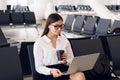 Young elegant business woman in international airport terminal, working on her laptop while waiting for flight Royalty Free Stock Photo