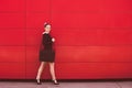 Young elegant business woman walk in front red wall in the city Royalty Free Stock Photo