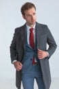 Young elegant businessman arranging his coat, looking away Royalty Free Stock Photo