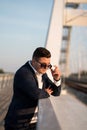 Young elegant businessman standing on a bridge by the railroad Royalty Free Stock Photo