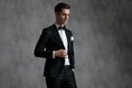 Young elegant groom wearing tuxedo and arranging coat Royalty Free Stock Photo