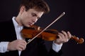 Young elegant male violinist violinist plays classical music on the violin. Royalty Free Stock Photo