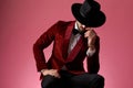 Young elegant man in red velvet tuxedo covering face with hat Royalty Free Stock Photo