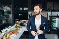 Young elegant man standing in the restaurant, holding a glass of wine. Man's style Royalty Free Stock Photo