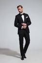 Young elegant man in tuxedo fixing his cufflinks Royalty Free Stock Photo