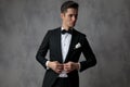 Young elegant man wearing tuxedo and arranging coat Royalty Free Stock Photo