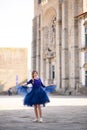 Young elegant woman in blue long flying dress posing at stairway against old city building Royalty Free Stock Photo