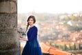 Young elegant woman in blue long flying dress posing at stairway against old city building Royalty Free Stock Photo