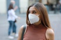 Young elegant woman in city street wearing KN95 FFP2 protective mask Royalty Free Stock Photo