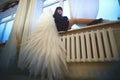 Young elegant woman in trendy black clothes with white wings. Brunette model in nice dark dress posing in studio in Royalty Free Stock Photo