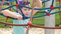 Young elementary school age girl wearing a baseball cap playing on the playground, climbing, portrait, face closeup, slow motion Royalty Free Stock Photo