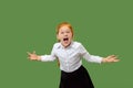 The young emotional angry teen girl screaming on green studio background Royalty Free Stock Photo