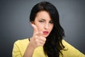 Young emotional beauty woman pointing you, standing on gray background Royalty Free Stock Photo