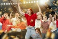 Young emotional woman with her little daughter visiting football match. Sport fans loudly cheering up team. Scared and Royalty Free Stock Photo