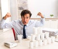 Young employee building pyramid from plastic cups Royalty Free Stock Photo