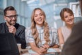 young employee enthusiastically tells something to her colleagues