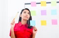 Young employee looking at multiple reminders while planning her