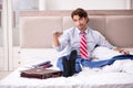 The young employee working at home sitting on the bed Royalty Free Stock Photo
