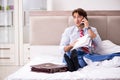 The young employee working at home sitting on the bed Royalty Free Stock Photo