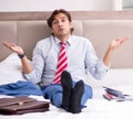 The young employee working at home sitting on the bed Royalty Free Stock Photo