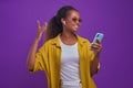 Young energetic African American woman listens to music with mobile phone Royalty Free Stock Photo