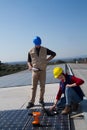 Young engineer girl and skilled worker on a roof Royalty Free Stock Photo