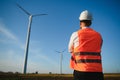Young engineer man looking and checking wind turbines at field Royalty Free Stock Photo