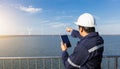 Young engineer man looking and checking wind turbines at field outdoor Royalty Free Stock Photo