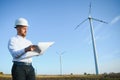 Young engineer man looking and checking wind turbines at field Royalty Free Stock Photo