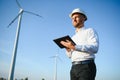 Young engineer man looking and checking wind turbines at field Royalty Free Stock Photo