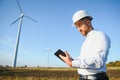 Young engineer man looking and checking wind turbines at field Royalty Free Stock Photo