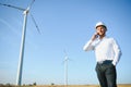 Young engineer man looking and checking wind turbines at field Royalty Free Stock Photo