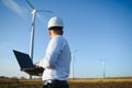 Young engineer man looking and checking wind turbines at field Royalty Free Stock Photo