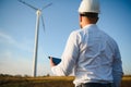 Young engineer man looking and checking wind turbines at field Royalty Free Stock Photo