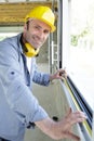 Young engineer or worker with safety helme using tape measure