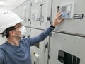Young engineer working in electrical substation wearing a face mask. Royalty Free Stock Photo