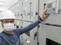 Young engineer working in electrical substation wearing a face mask. Royalty Free Stock Photo