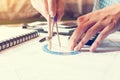 Young engineering man drawing compass on blueprints.