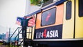 Young engineering students holding high the Malaysia flag in front of the rapidKL train