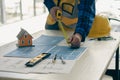 Young engineers and architects design, plan, measure the layout of blueprints with tabletop tools in construction concepts with ha Royalty Free Stock Photo